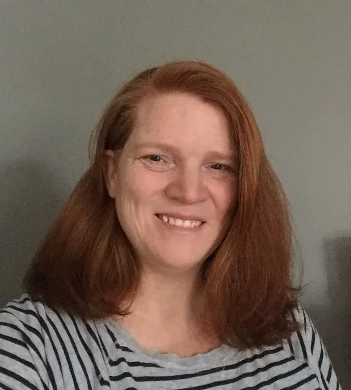 Lauren Van Ewyk, smiling, with shoulder-length red hair
